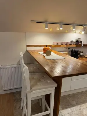 a kitchen with a large wooden table with a chair at Rainbow Hill in Giebułtów