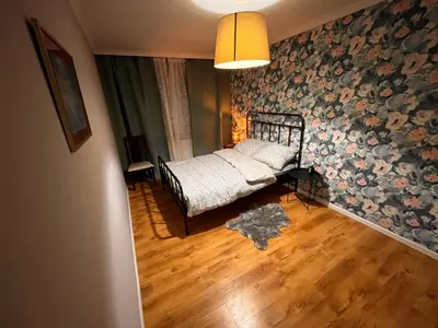 a bedroom with a bed with a floral wall at Blue Apartment KRK with Balcony in Kraków