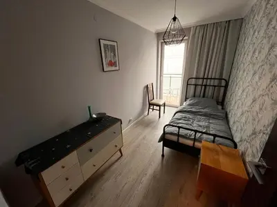 a bedroom with a bed and a dresser and a window at Blue Apartment KRK with Balcony in Kraków