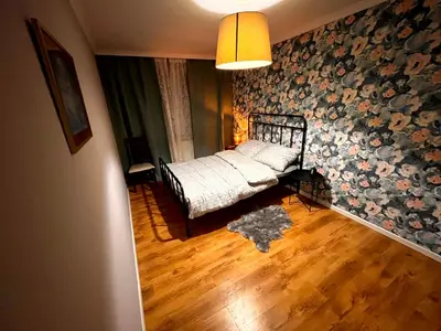 a bedroom with a bed with a floral wall at Blue Apartment KRK with Balcony in Kraków