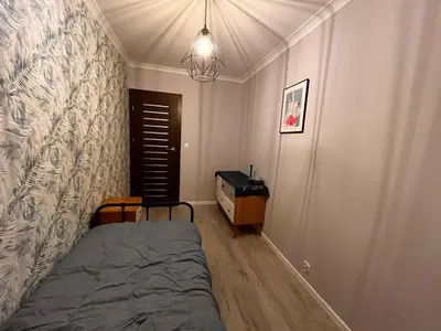 a bedroom with a bed and a table in it at Blue Apartment KRK with Balcony in Kraków