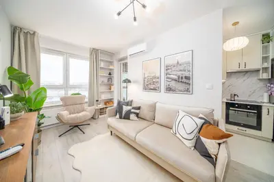 a living room with a couch and a kitchen at Tauron Arena - Parking, Balcony, AirCon - by Rentujemy in Kraków
