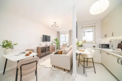 a kitchen and a living room with a table at Tauron Arena - Parking, Balcony, AirCon - by Rentujemy in Kraków