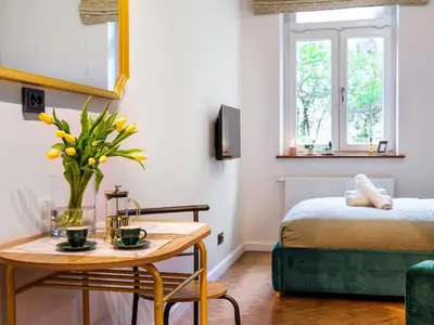 a room with a bed and a table with flowers on it at Quiet Courtyard Studio by Tyzenhauz in Kraków