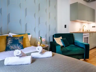 a bedroom with a bed and a green couch at Quiet Courtyard Studio by Tyzenhauz in Kraków