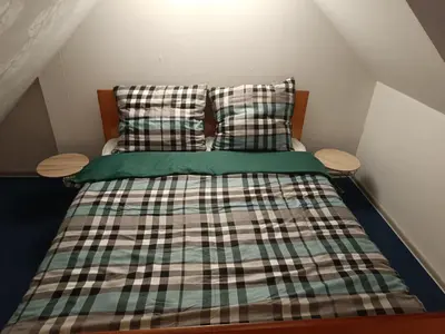 a bedroom with a bed with plaid sheets and pillows at Paula Apart in Wadowice