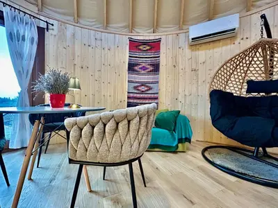 a bedroom with a bed with curtains and a table at Jurta Jura leśna in Przybysławice