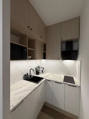 a white kitchen with a sink and a counter at Modern studio Old Town Railway Station in Kraków