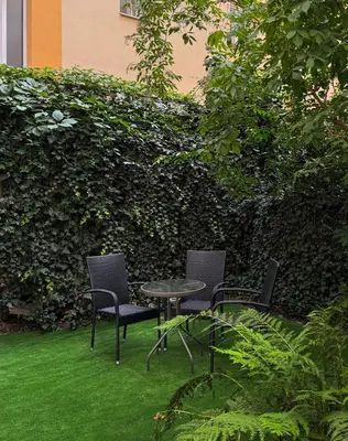 a table and chairs sitting on the grass in a garden at Modern studio Old Town Railway Station in Kraków