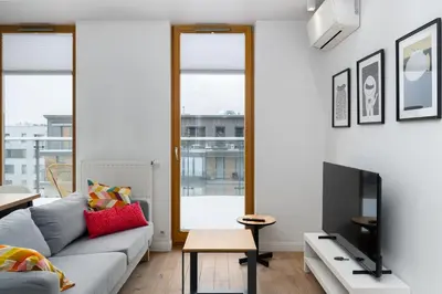 a living room with a couch and a tv at Bulwar Kurlandzki Downtown Apartment by BookingHost in Kraków