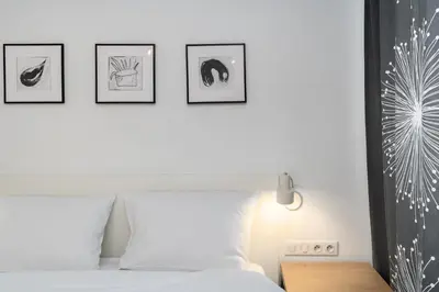 a bedroom with a bed with four pictures on the wall at Bulwar Kurlandzki Downtown Apartment by BookingHost in Kraków