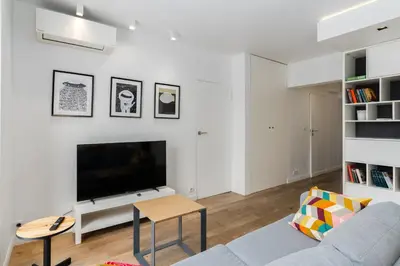 a living room with a couch and a tv at Bulwar Kurlandzki Downtown Apartment by BookingHost in Kraków