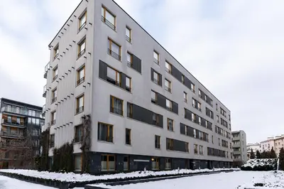 a large white building with snow on the ground at Bulwar Kurlandzki Downtown Apartment by BookingHost in Kraków