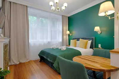 a hotel room with a bed and a table at Green & Gold Studio near Vistula by Tyzenhauz in Kraków