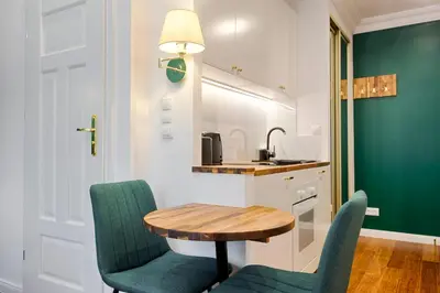a small kitchen with a table and two chairs at Green & Gold Studio near Vistula by Tyzenhauz in Kraków