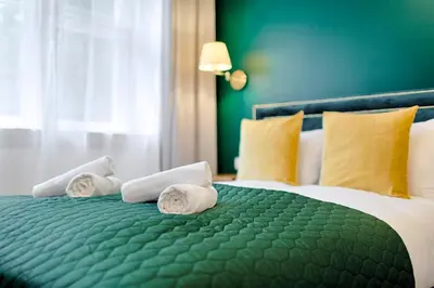 a bedroom with a bed with towels on it at Green & Gold Studio near Vistula by Tyzenhauz in Kraków