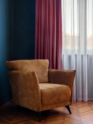 a brown chair sitting in front of a window at Royal Vistula Luxury Apartment in Kraków