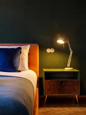 a bedroom with a bed and a lamp on a night stand at Royal Vistula Luxury Apartment in Kraków