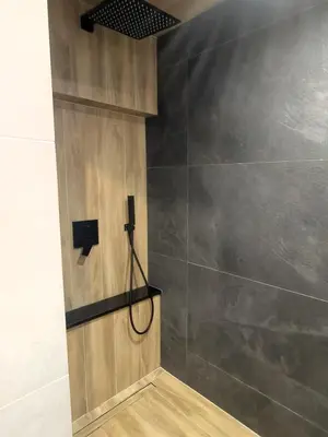 a bathroom with a shower with a wall at Apartament w górach SZCZEBEL in Tenczyn