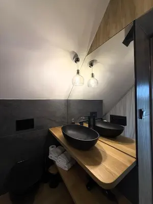 a bathroom with two black sinks on a wooden counter at Apartament w górach SZCZEBEL in Tenczyn