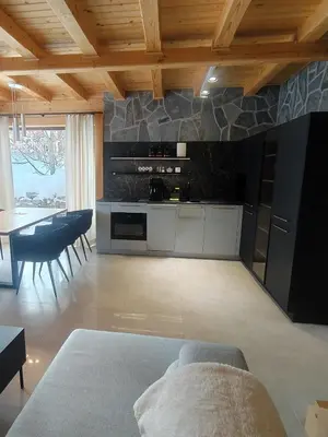 a living room with a kitchen and a dining room at Apartament w górach SZCZEBEL in Tenczyn