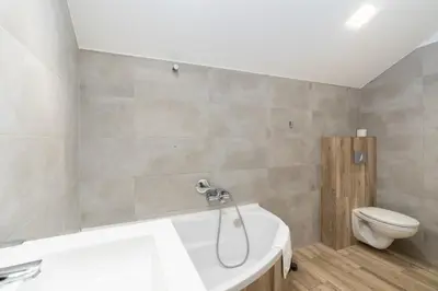 a bathroom with a bath tub and a toilet at Bosacka Downtown Apartment by BookingHost in Kraków