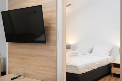 a room with a bed and a flat screen tv at Bosacka Downtown Apartment by BookingHost in Kraków