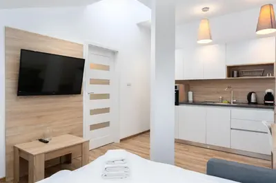 a living room with a tv and a kitchen at Bosacka Downtown Apartment by BookingHost in Kraków