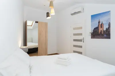 a bedroom with a white bed and a mirror at Bosacka Downtown Apartment by BookingHost in Kraków