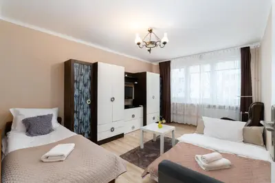 a bedroom with two beds and a white dresser at Jaremy Standard Apartment by BookingHost in Kraków