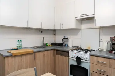 a kitchen with white cabinets and a stove top oven at Jaremy Standard Apartment by BookingHost in Kraków