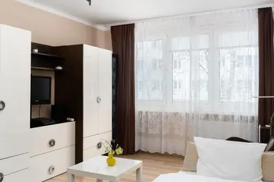 a living room with a white couch and a window at Jaremy Standard Apartment by BookingHost in Kraków