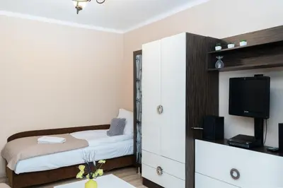 a small bedroom with a bed and a tv at Jaremy Standard Apartment by BookingHost in Kraków