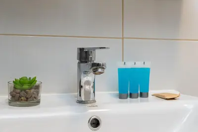 a kitchen sink with a faucet on a counter at Jaremy Standard Apartment by BookingHost in Kraków