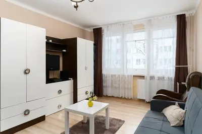a living room with a blue couch and a tv at Jaremy Standard Apartment by BookingHost in Kraków
