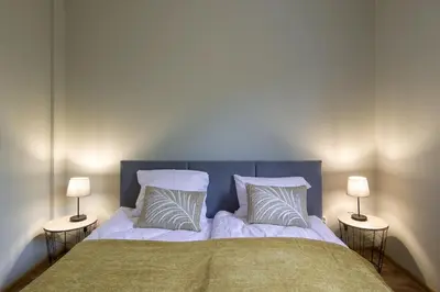 a bedroom with a bed with two lamps on both sides at Spacious oasis in the center in Kraków
