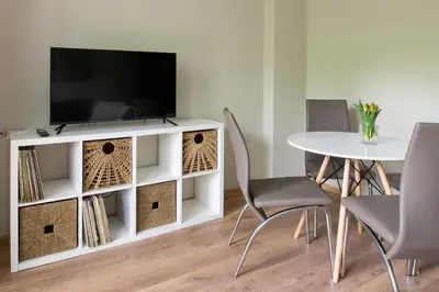a living room with a tv and a table and chairs at Spacious oasis in the center in Kraków
