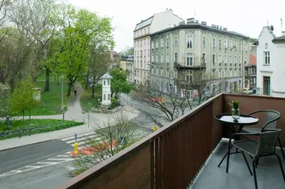 a balcony with a table and chairs and a street at Spacious oasis in the center in Kraków