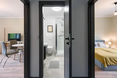 a bedroom with a bed and a room with a desk at Spacious oasis in the center in Kraków