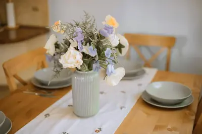 a vase filled with flowers sitting on a table at Kraków Modern Apartment | 6 Guests, Parking/Tram in Kraków