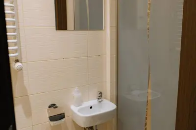 a bathroom with a white sink and a shower at Kraków Modern Apartment | 6 Guests, Parking/Tram in Kraków