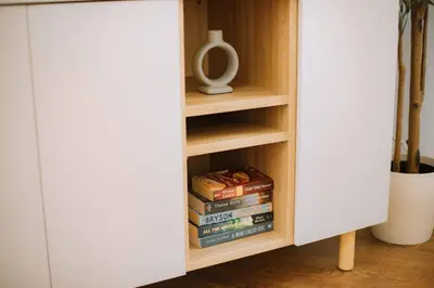 a book shelf with books in a white cabinet at Kraków Modern Apartment | 6 Guests, Parking/Tram in Kraków
