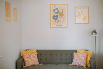 a living room with a gray couch and two pillows at Kraków Modern Apartment | 6 Guests, Parking/Tram in Kraków