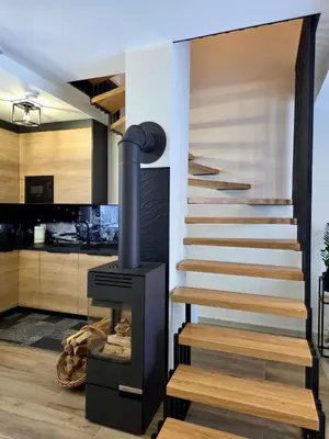 a staircase with a stove next to a kitchen at Domki Leśne Zacisze in Baczyn
