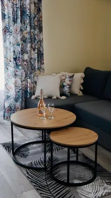 a table with wine glasses and a bottle on it in a living room at Domki Leśne Zacisze in Baczyn