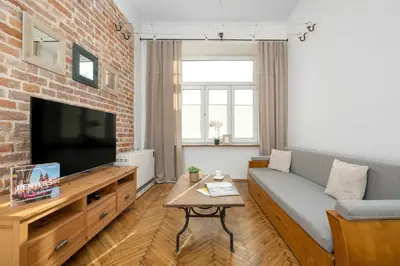 a living room with a couch and a television at Atmospheric Apartment Close to the Vistula Boulevards by Noclegi Renters in Kraków