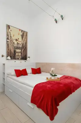 a white bedroom with a red blanket on a bed at Atmospheric Apartment Close to the Vistula Boulevards by Noclegi Renters in Kraków