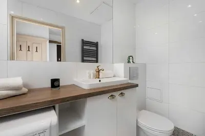 a white bathroom with a sink and a toilet at Atmospheric Apartment Close to the Vistula Boulevards by Noclegi Renters in Kraków