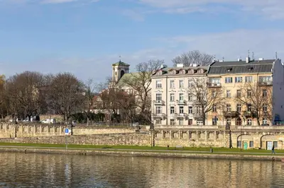 a large building next to a body of water at Atmospheric Apartment Close to the Vistula Boulevards by Noclegi Renters in Kraków
