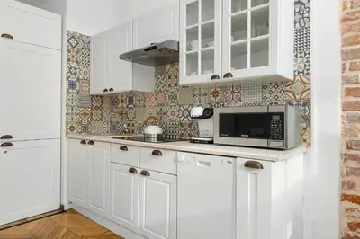 a kitchen with white cabinets and a microwave at Atmospheric Apartment Close to the Vistula Boulevards by Noclegi Renters in Kraków